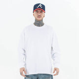 Model wearing front view of classic crew neck solid color custom long sleeve t-shirt.