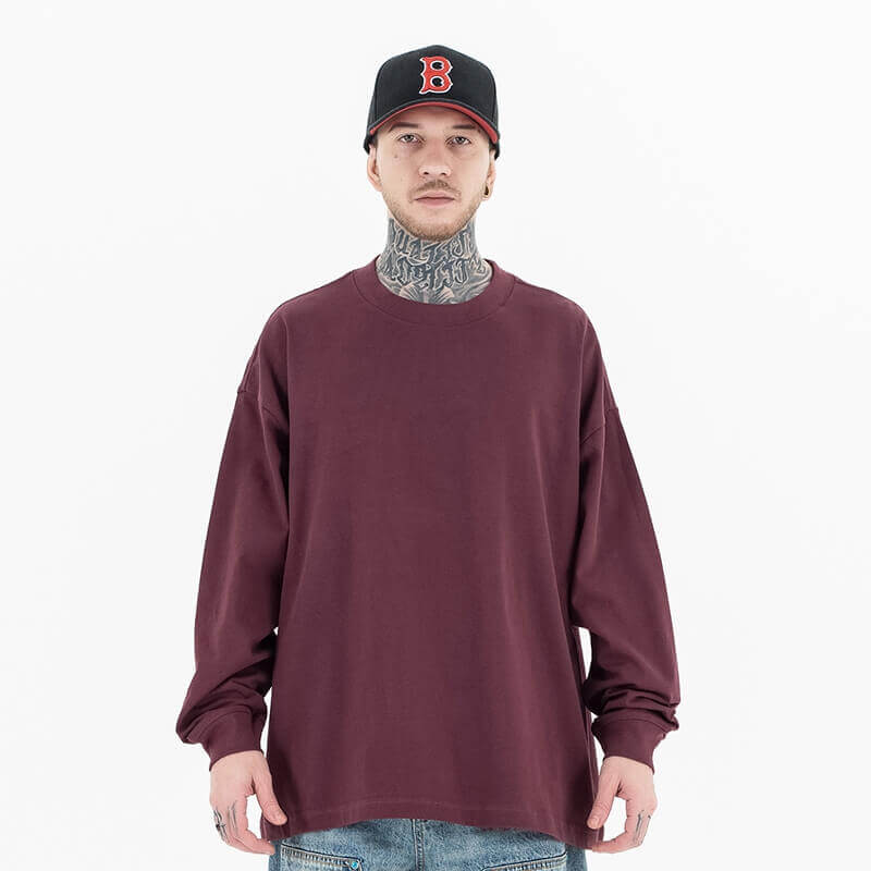 Model wearing front view of classic crew neck solid color custom long sleeve t-shirt.