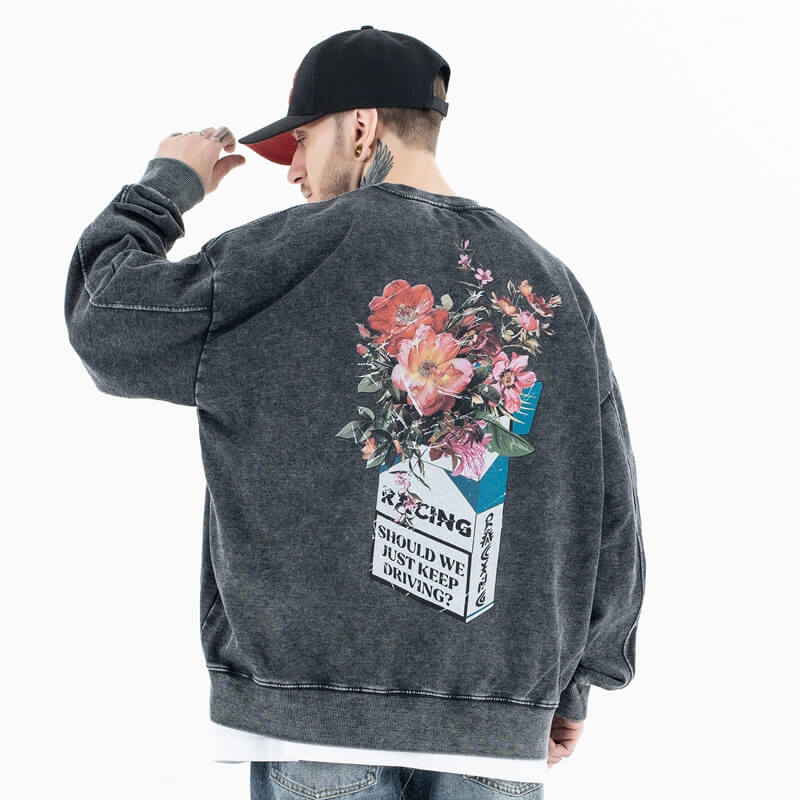 Back view of model wearing a vintage wash crew neck flower graphic sweatshirt.