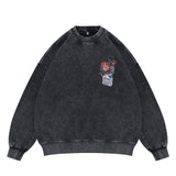 Flat lay of a black vintage wash crew neck sweatshirt with a floral graphic design.