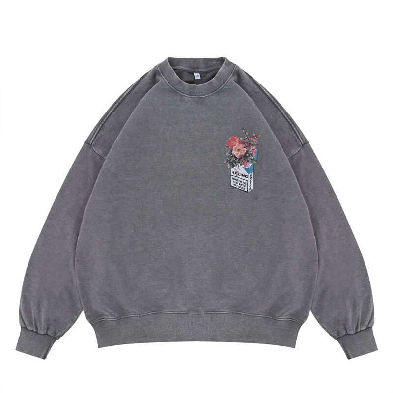 Flat lay of a gray vintage wash crew neck sweatshirt with a floral graphic design.